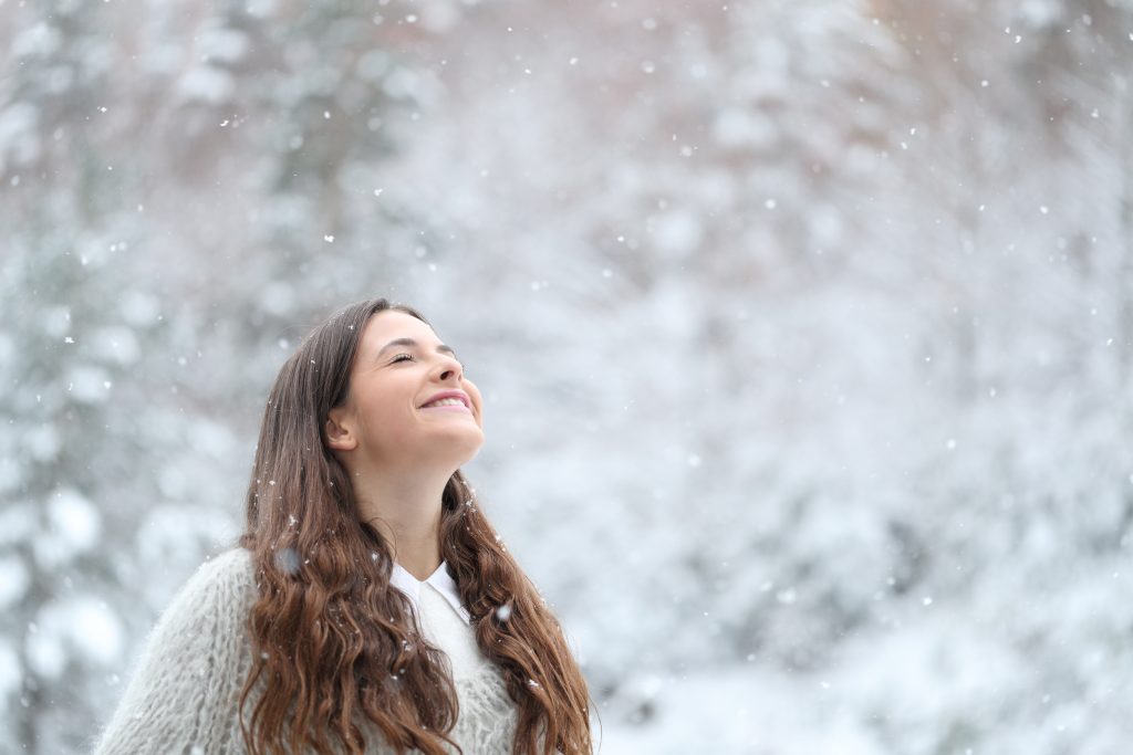 Portrait of a happy teenage girl enjoying a snowy day in winter